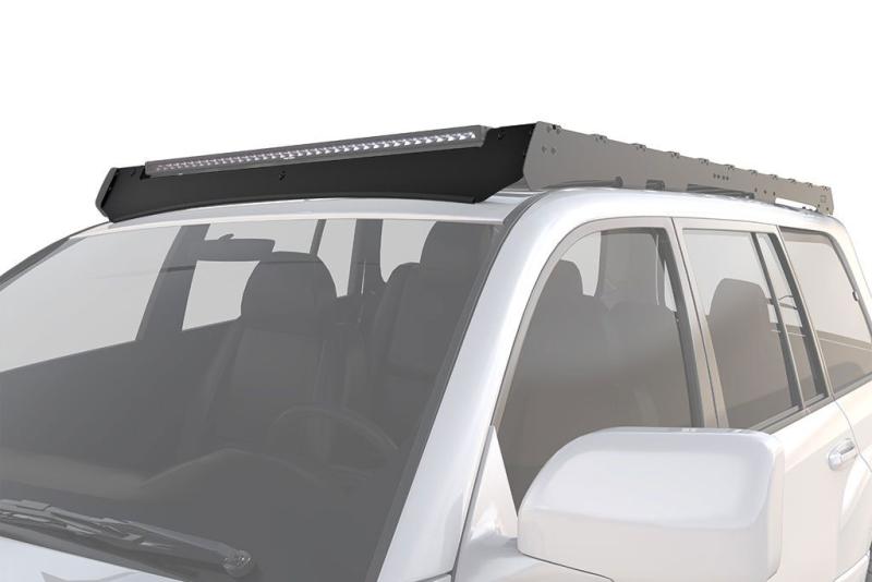 Deflector de viento para baca Slimsport Toyota Land Cruiser 100 Series - Reduzca de forma masiva el ruido del viento y el consumo de combustible con el deflector para viento para barra de luces de la Toyota Land Cruiser. Desplazar inteligentemente el flujo de aire hacia arriba y por encima de su baca portaequipajes y accesorios. Una hoja de goma duradera sella la brecha entre el deflector y su Cruiser mientras lo protege cuando fuera de la carretera.