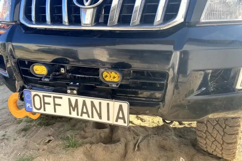 Folding license plate holder for winch guide and spotlight holder